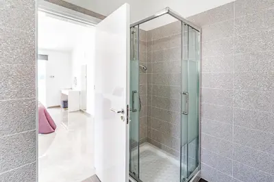 a shower with a glass door in a bathroom at Beach Front Aqua Marina by Ezoria Villas in Paralimni