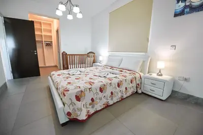 a bedroom with a large bed and a night stand at Beach Front Bella Vista by Ezoria Villas in Protaras