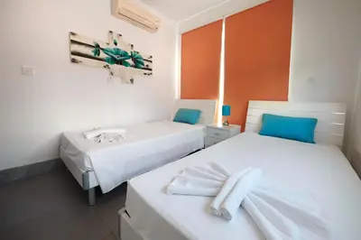 two beds in a room with white and blue at Beach Front Bella Vista by Ezoria Villas in Protaras