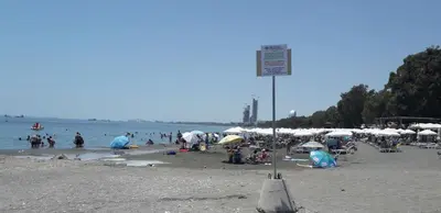 a group of people on a beach with umbrellas at Chrysanthos Boutique Apartments in Limassol
