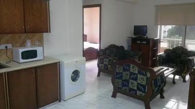 a kitchen with a washing machine and a microwave at Chrysanthos Boutique Apartments in Limassol