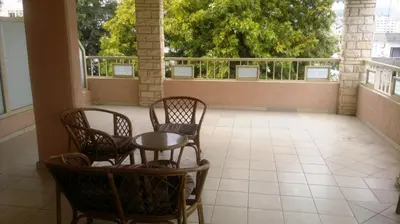 a balcony with three chairs and a table on a balcony at Chrysanthos Boutique Apartments in Limassol