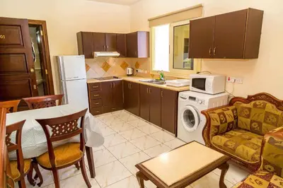 a kitchen with a couch a table and a microwave at Chrysanthos Boutique Apartments in Limassol