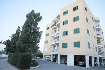 a tall building with cars parked in front of it at Bianco E U Apartment in Nicosia