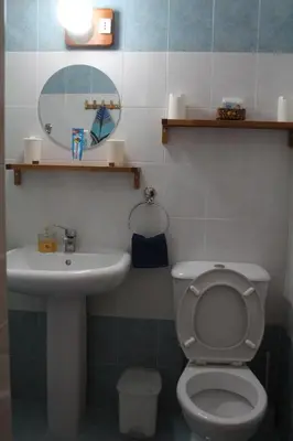 a bathroom with a toilet and a sink and a mirror at Montehugh in Larnaka