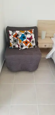 a couch in a living room with a pillow on it at Sunny Napa Apartments in Ayia Napa