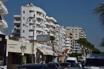 a city street with cars parked in front of tall buildings at Kolonaki Seaview Apartments in Larnaka