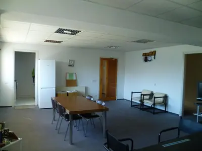 a room with a table and chairs and a refrigerator at Datacom Guest House in Nicosia