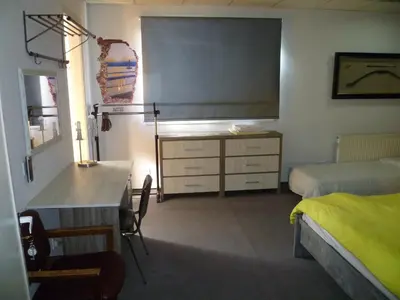 a bedroom with a bed and a dresser and a desk at Datacom Guest House in Nicosia