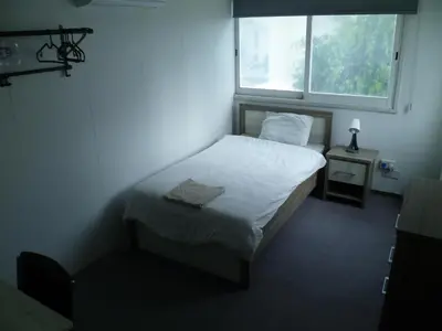 a small bedroom with a bed and a window at Datacom Guest House in Nicosia