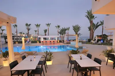 a view of a resort with tables and chairs and a pool at Okeanos Beach Boutique Hotel in Ayia Napa