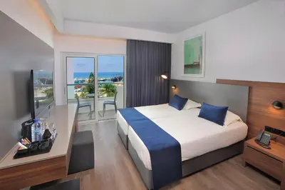 a hotel room with a bed and a balcony at Okeanos Beach Boutique Hotel in Ayia Napa