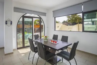 a dining room with a wooden table and chairs at Villa Mylos 8 in Protaras