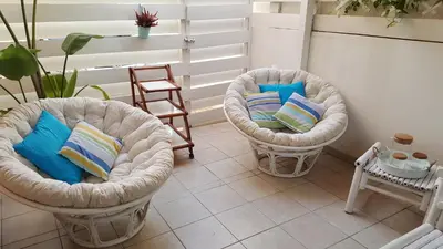 two wicker chairs with pillows in a living room at Million flowers in Protaras