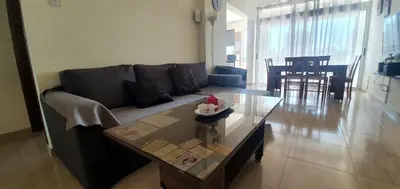 a living room with a couch and a table at Vasilas Holiday Apartment #1 in Larnaka
