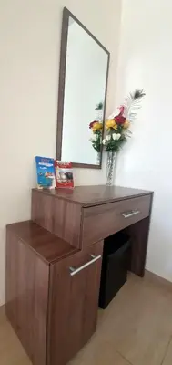 a wooden dresser with a mirror and flowers on it at Vasilas Holiday Apartment #1 in Larnaka