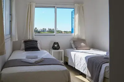 two beds in a small room with a window at Phaedrus Living: Seaside Luxury Villa Anafi in Paralimni