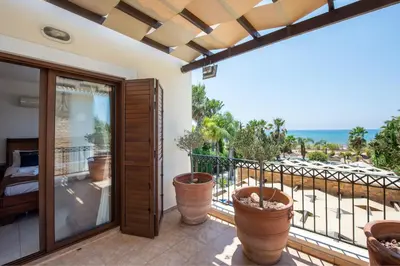 a balcony with potted plants and a view of the ocean at Sea Front Costa Blu by Ezoria Villas in Ayia Napa