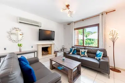 a living room with a couch and a fireplace at Sea Front Costa Blu by Ezoria Villas in Ayia Napa