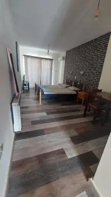 a bedroom with a bed and a brick wall at Pomelo Apartments in Ayia Napa