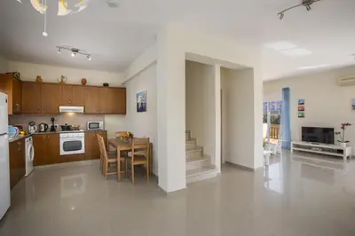 a kitchen and dining room with a table and a dining room at Protaras Galleria Sunset Villa in Paralimni