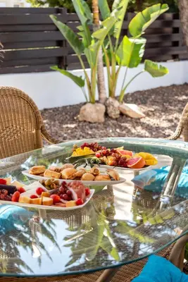 two plates of food on a glass table at Villa Willow Mandali by Ezoria Villas in Protaras