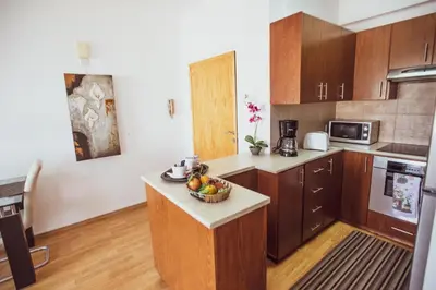 a kitchen with wooden cabinets and a bowl of fruit on a counter at Beach Haven in Larnaka
