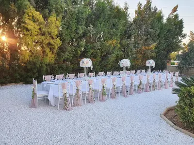 a row of tables and chairs with flowers on them at Larnaca Mansion Ideal for 3 Families or more in Larnaka
