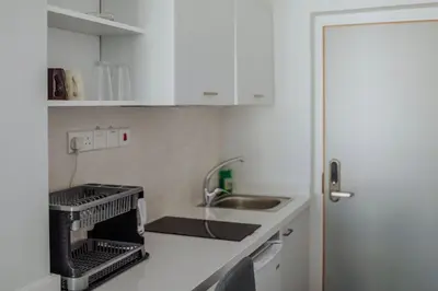 a small kitchen with white cabinets and a sink at River View Boutique Apts in Ayia Napa