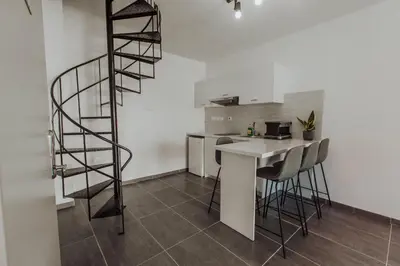 a kitchen with a spiral staircase and a table and chairs at River View Boutique Apts in Ayia Napa