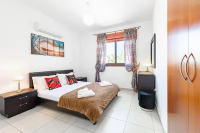 a bedroom with a bed and a window at Sea Front Oceanus H2 by Ezoria Villas in Ayia Napa
