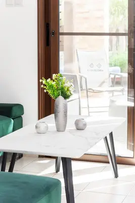 a white coffee table with a vase on it at Villa Poseidon by Ezoria Villas in Ayia Napa