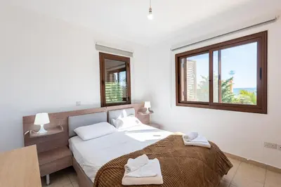 a bedroom with a bed with two towels on it at Villa Poseidon by Ezoria Villas in Ayia Napa