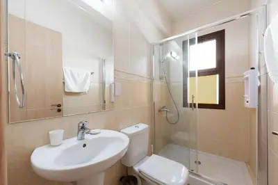 a bathroom with a sink and a toilet and a shower at Villa Poseidon by Ezoria Villas in Ayia Napa