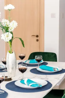 a table with blue and white plates and a vase with flowers at Villa Poseidon by Ezoria Villas in Ayia Napa