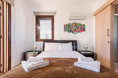 a bedroom with a large bed with towels on it at Villa Poseidon by Ezoria Villas in Ayia Napa