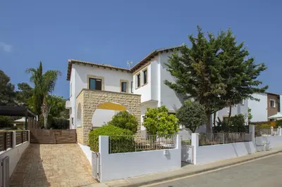 a white house with a white fence and trees at Konnos Blue in Protaras