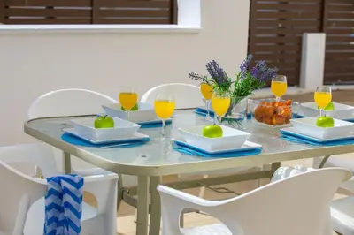 a table with plates and glasses of orange juice at Konnos Blue in Protaras