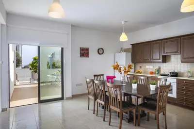 a kitchen and dining room with a table and chairs at Konnos Blue in Protaras