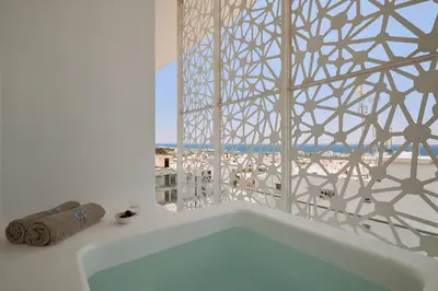 a bath tub in a bathroom with a window at Hotel Napa Suites (Adults Only) in Ayia Napa