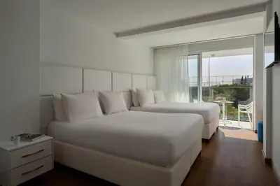 a hotel room with two beds and a large window at Hotel Napa Suites (Adults Only) in Ayia Napa