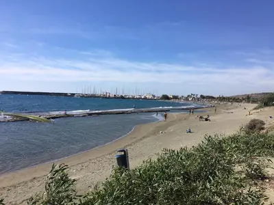 a beach with people on the sand and water at Sunny Garden Limassol Star in Limassol