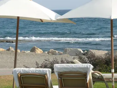 two chairs and an umbrella on the beach at Sunny Garden Limassol Star in Limassol