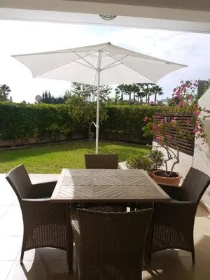 a table and chairs with an umbrella on a patio at Sunny Garden Limassol Star in Limassol