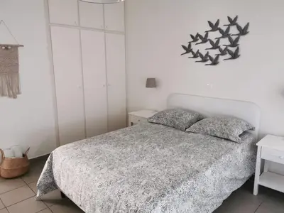 a bedroom with a bed and a white wall at Nostalgia apts in Limassol