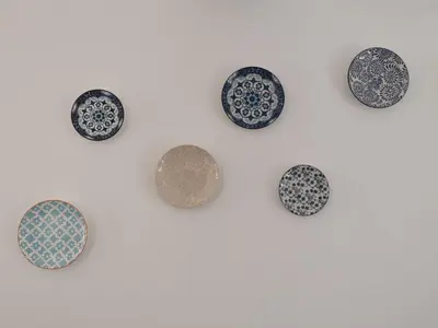 a group of plates on a white wall at Nostalgia apts in Limassol