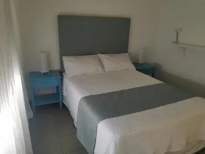 a bedroom with a bed and two blue tables at Nostalgia apts in Limassol