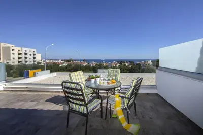 a table and chairs on a balcony with a view at Green Bay Penthouse 2 in Protaras