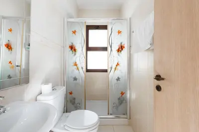 a bathroom with a toilet and a sink and a shower at Villa Iris by Ezoria Villas in Ayia Napa