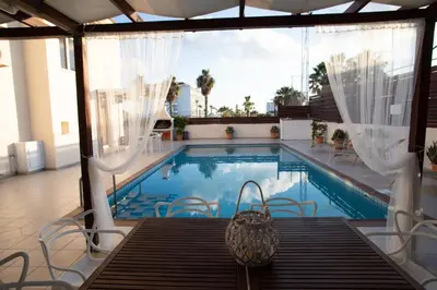 a swimming pool with a table and chairs next to it at Athena Villa in Ayia Napa